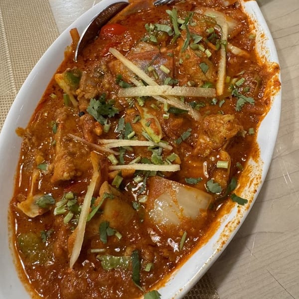 Clay Pit's Indian chicken curry with vegetables, garnished with fresh cilantro and ginger slivers.